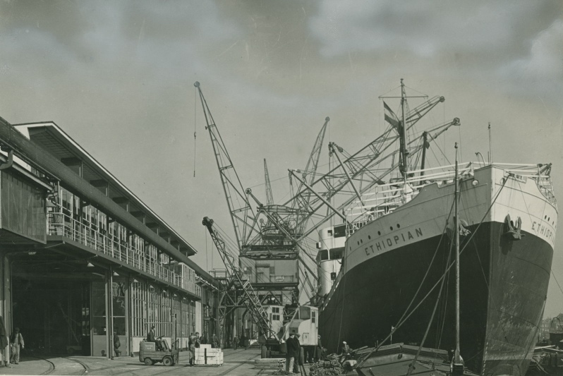 Het schip Ethiopian naast het poortgebouw en de havenkranen